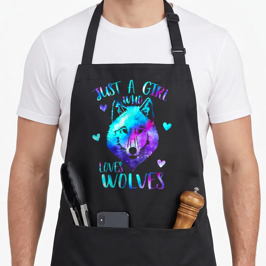 Themed wolves apron - Watercolor wolf head in blue and purple with text JUST A GIRL WHO LOVES WOLVES and four hearts — shown on a black cotton canvas apron against a white background