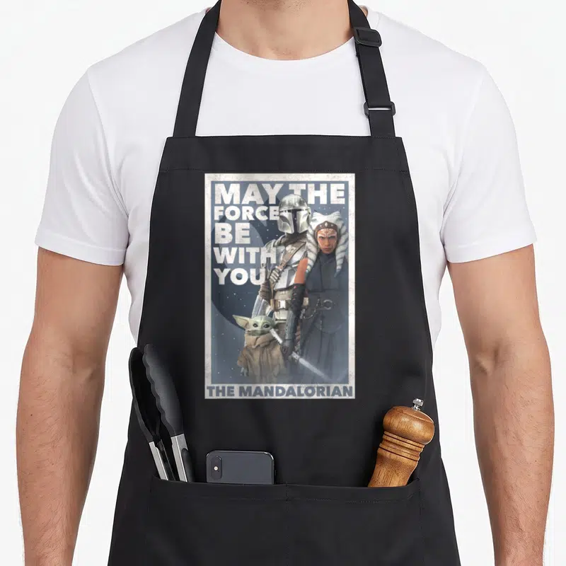 Force may look apron - Mandalorian Ahsoka and Grogu photo with May The Force Be With You text — shown on a black cotton canvas apron against a white background
