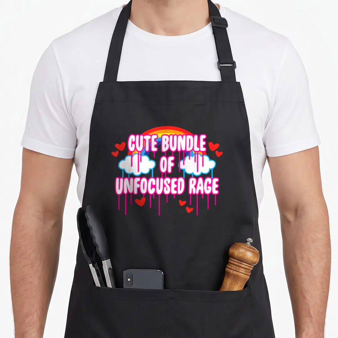 Bundle drip apron - Stacked text Cute Bundle of Unfocused Rage with rainbow arch, white clouds, pink drips, and red — shown on a black cotton canvas apron against a white background