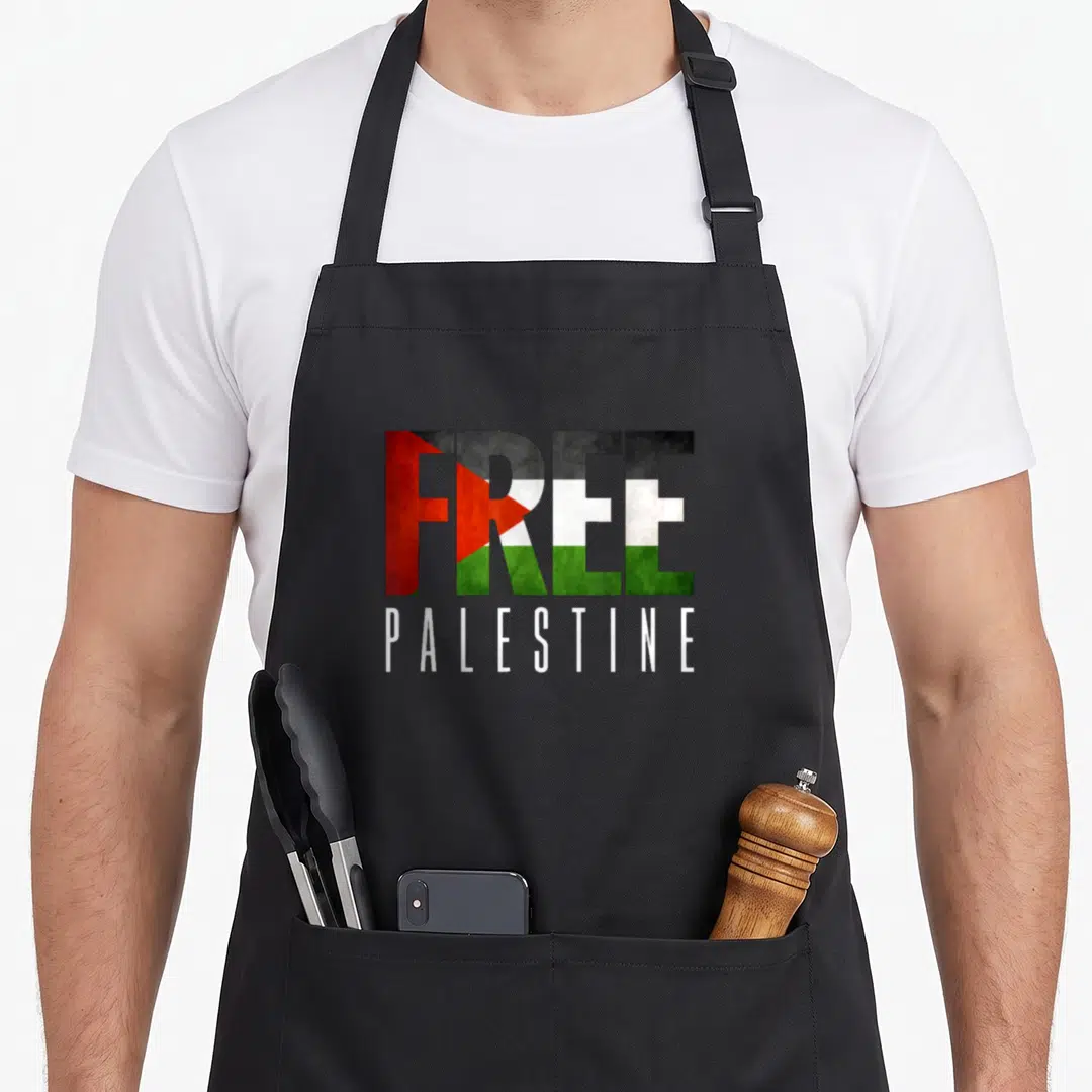 Free palestine apron for women - Stacked text reading FREE PALESTINE with flag pattern fill in red black white green — shown on a black cotton canvas apron against a white background