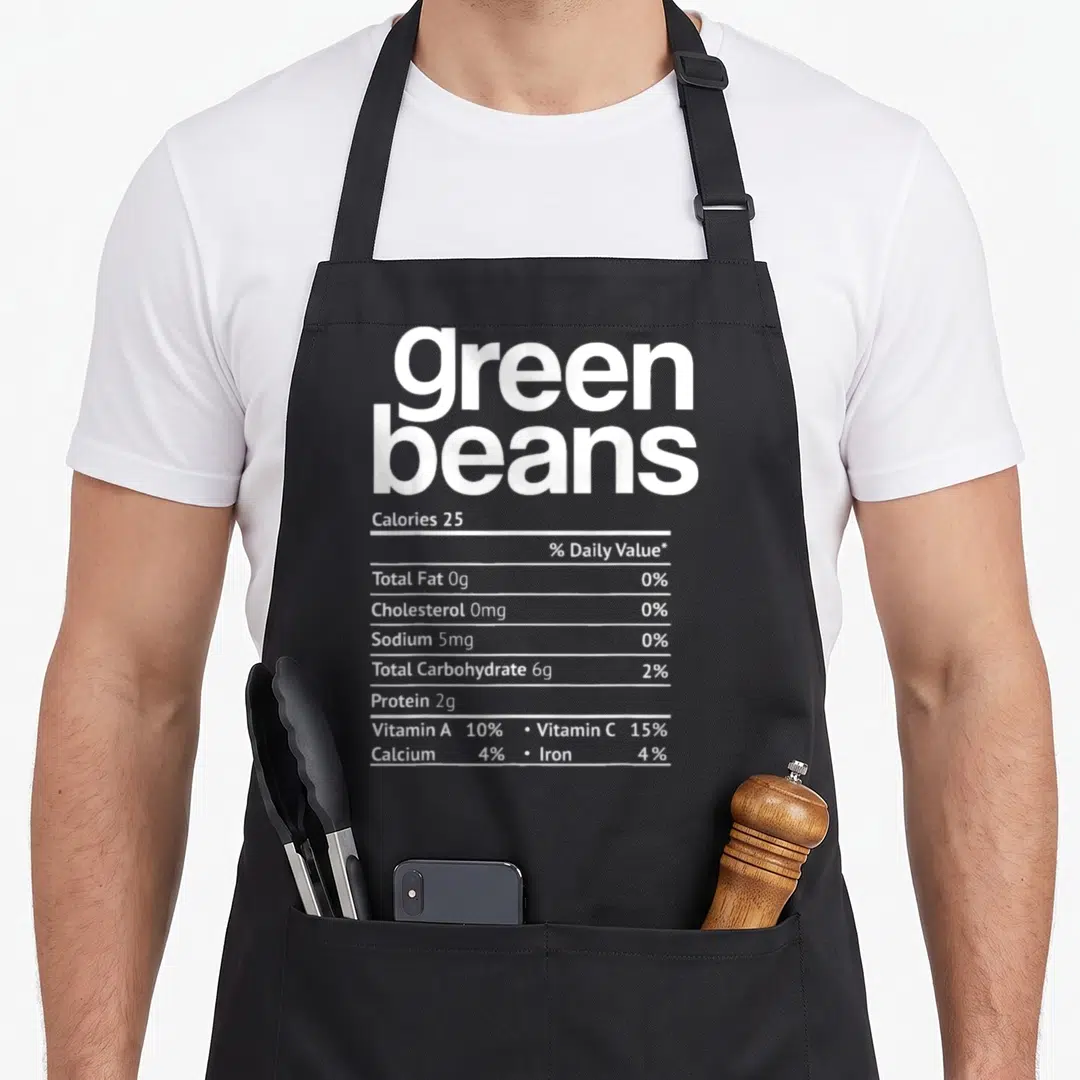 Bean green christmas apron - White typography on grey background showing nutrition facts label for green beans — shown on a black cotton canvas apron against a white background
