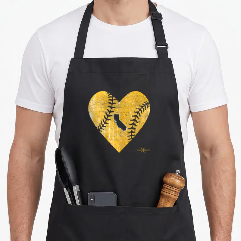 Oakland baseball apron - Yellow heart baseball shape with grey California silhouette and white stitching on black fabric — shown on a black cotton canvas apron against a white background