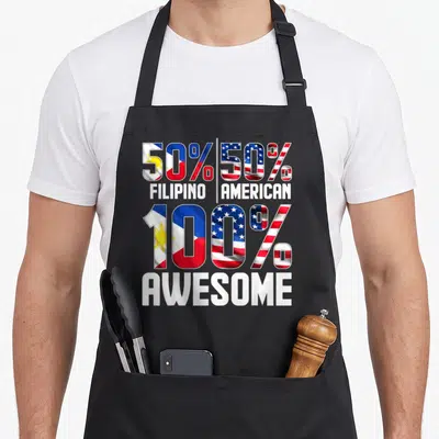 Funny filipino patriotic apron - 50% Filipino 50% American 100% Awesome flag typography design — shown on a black cotton canvas apron against a white background