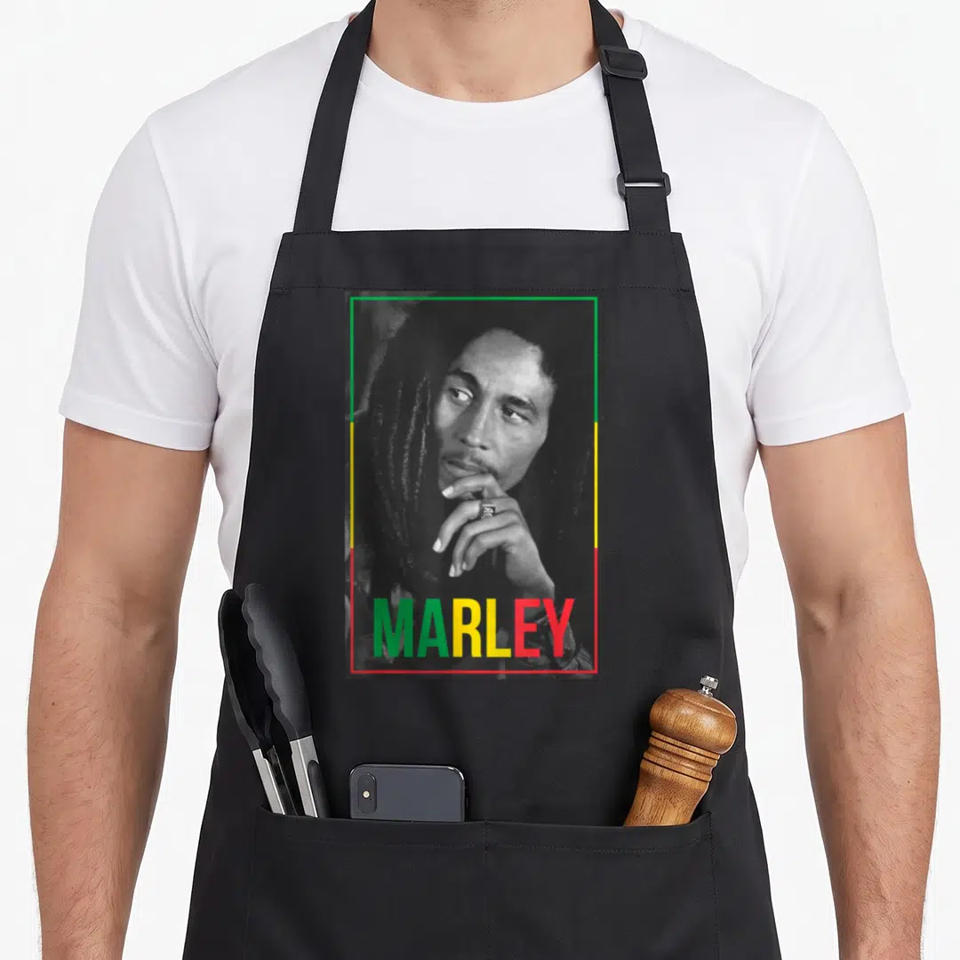Bob white apron - Monochrome man portrait in green yellow red border with multicolored text at bottom — shown on a black cotton canvas apron against a white background
