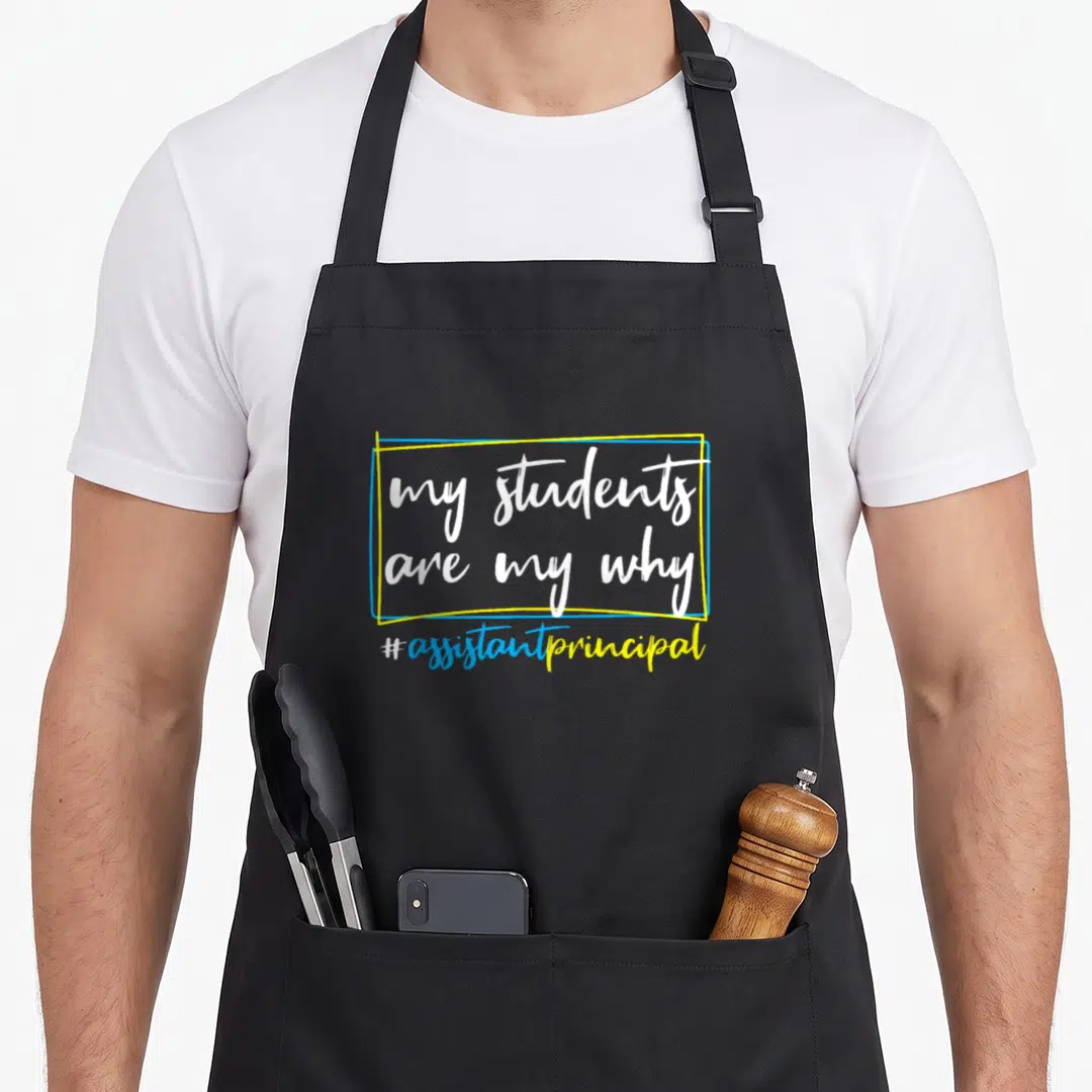 Assistant student aprons - my students are my why hashtag assistant principal text in yellow blue white frame — shown on a black cotton canvas apron against a white background