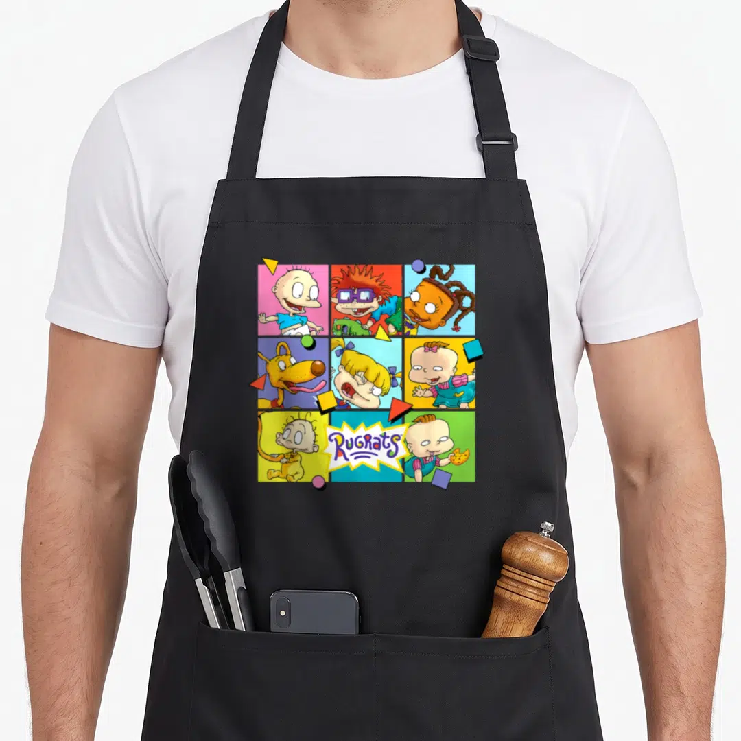 Squad square apron - 3x3 grid of Rugrats characters in pink, red, blue, yellow, and green with logo — shown on a black cotton canvas apron against a white background
