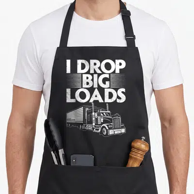 Trucker semi truck apron - White distressed I DROP BIG LOADS text above semi-truck illustration on black apron — shown on a black cotton canvas apron against a white background