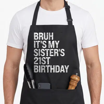 Sister queen of baking apron - White distressed text reading BRUH IT'S MY SISTER'S 21ST BIRTHDAY stacked vertically — shown on a black cotton canvas apron against a white background