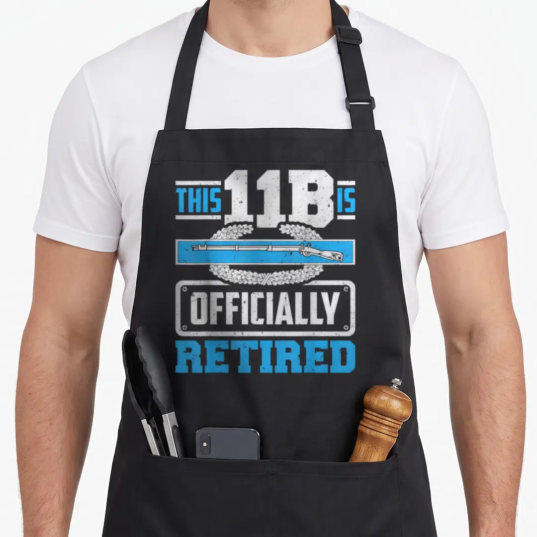 Retired combat apron - Rifle and laurel wreath with THIS 11B IS OFFICIALLY RETIRED text in blue white grey distressed — shown on a black cotton canvas apron against a white background