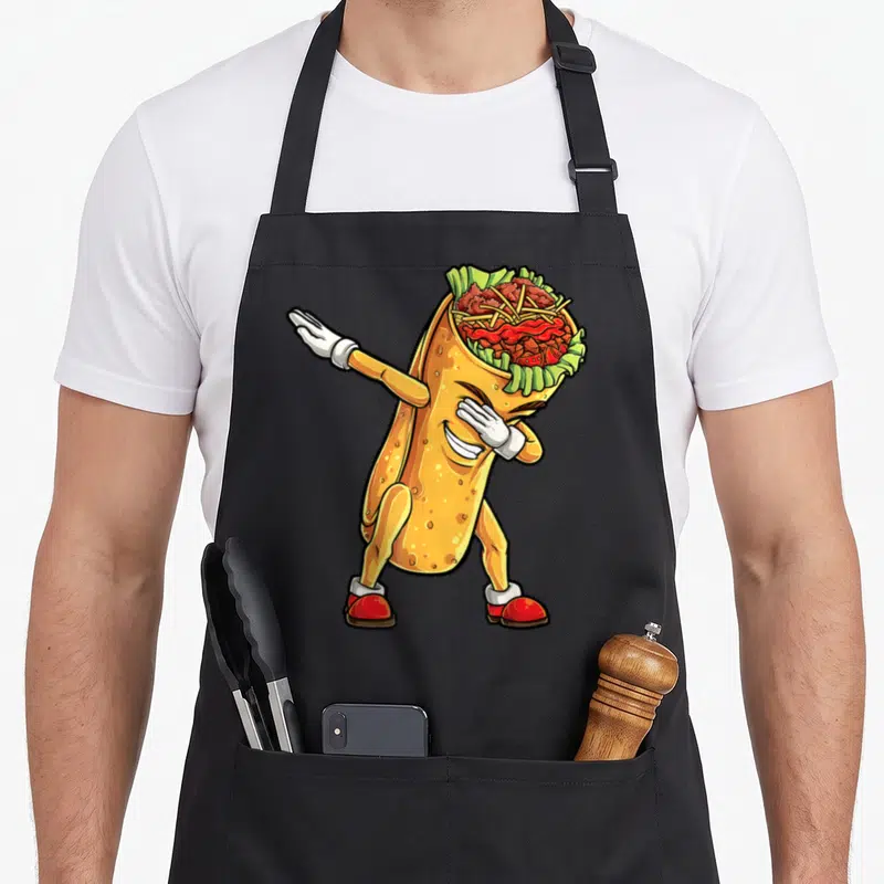 Dabbing burrito apron - Cartoon burrito character dabbing with visible fillings in yellow, green, brown, red, and white — shown on a black cotton canvas apron against a white background