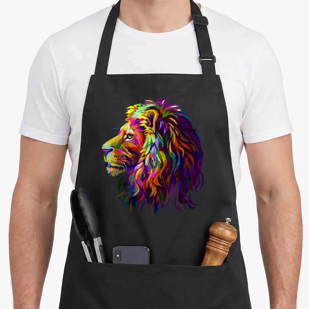 Lion colorful apron - Multicolored realistic lion head profile in purple blue yellow red green pop art — shown on a black cotton canvas apron against a white background