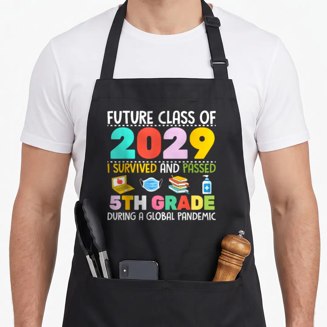 Future fifth apron - Stacked text reading Future Class of 2029 with laptop mask books and sanitizer icons — shown on a black cotton canvas apron against a white background