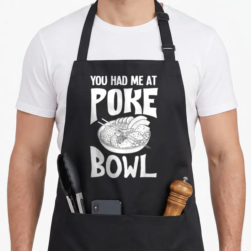 Poke recipe apron - White line art of poke bowl with chopsticks and text you had me at poke bowl — shown on a black cotton canvas apron against a white background