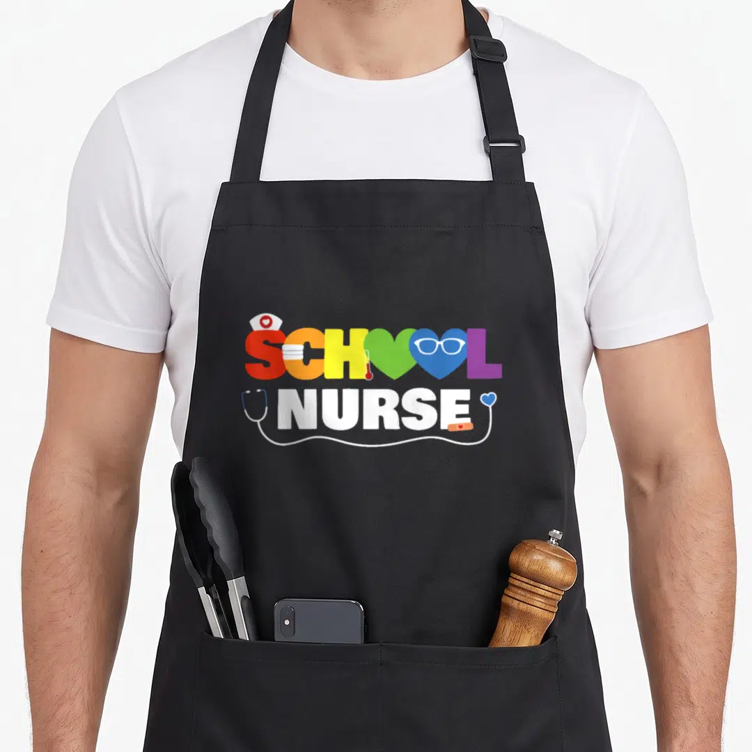 School registered nurse apron - Rainbow SCHOOL NURSE text with nurse hat, thermometer, glasses, and stethoscope cord — shown on a black cotton canvas apron against a white background