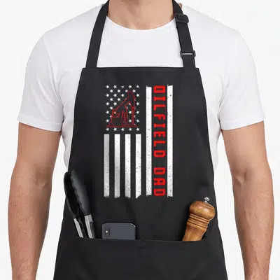 Roughneck rig dad apron - Distressed vertical flag with oil pump jack and red DILDFIELD DAD text — shown on a black cotton canvas apron against a white background