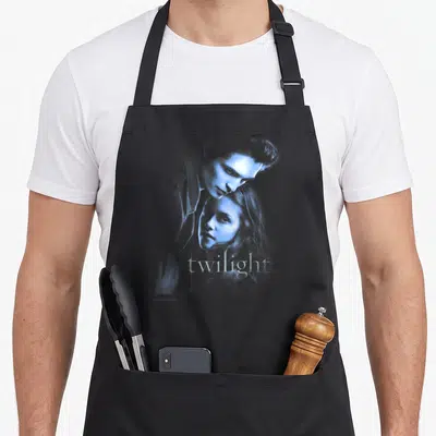 Twilight edwards aprons - Blue tinted photo of overlapping couple faces with twilight text centered at bottom — shown on a black cotton canvas apron against a white background