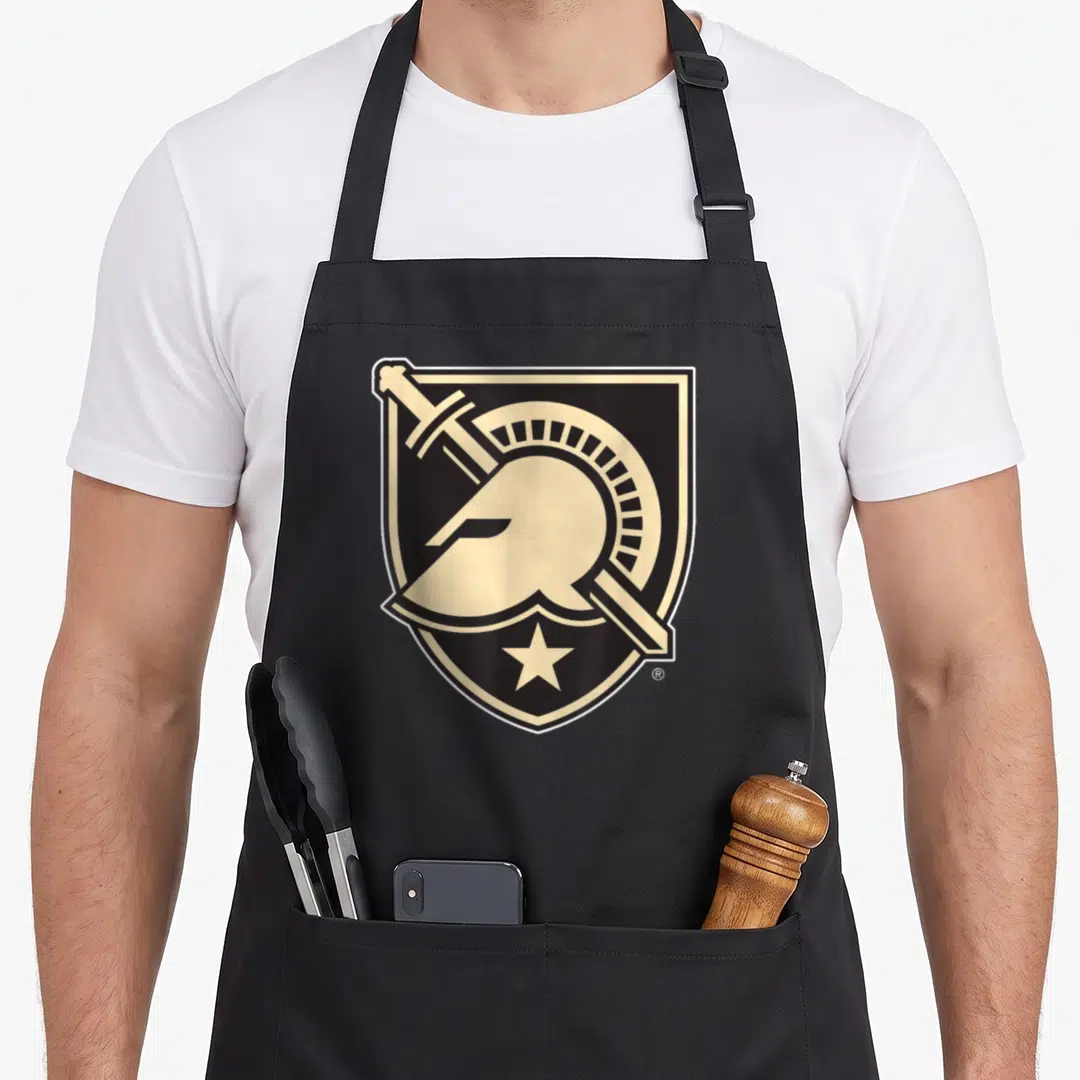 Knight army apron - Beige knight helmet and sword inside black shield with star at bottom point — shown on a black cotton canvas apron against a white background