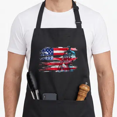 Stand captain apron - Captain America standing holding shield over distressed red white and blue American flag — shown on a black cotton canvas apron against a white background