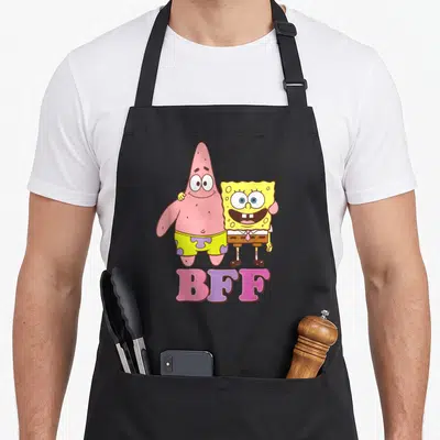Squarepant patricks apron - SpongeBob and Patrick standing with BFF text in yellow pink purple — shown on a black cotton canvas apron against a white background