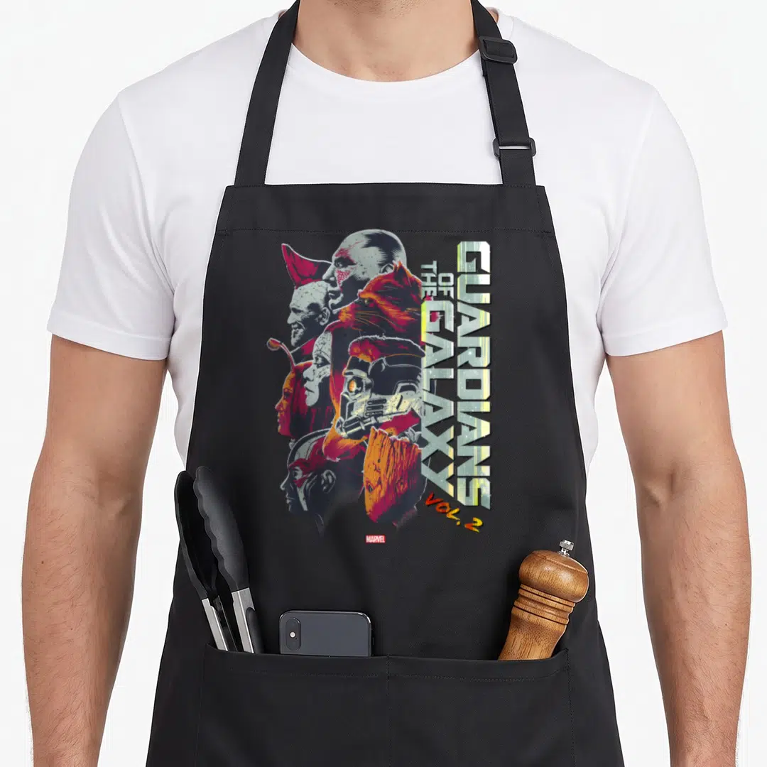 Epic galaxies apron - Guardians of the Galaxy Vol 2 vertical text with overlapping character faces in yellow red blue — shown on a black cotton canvas apron against a white background