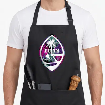 Funny seal guam aprons - Guam text with palm tree and boat inside leaf border on purple teal pink pattern — shown on a black cotton canvas apron against a white background