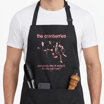 Everybody cranberries apron - Pink halftone band portrait with distressed text reading 'everybody else is doing it, so — shown on a black cotton canvas apron against a white background