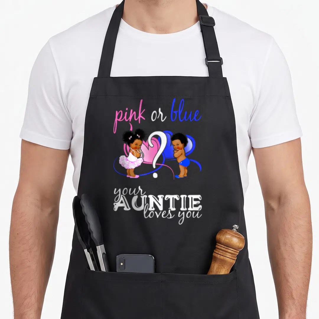 Reveal apron or apron - Two cartoon babies flank a white question mark with pink and blue hearts and text — shown on a black cotton canvas apron against a white background