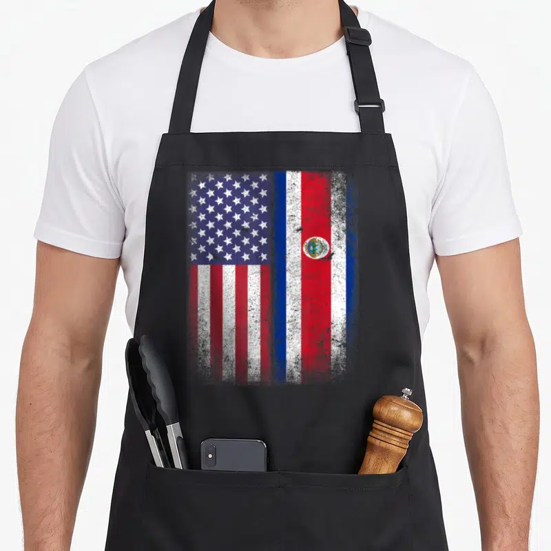Costa american flag apron - Distressed USA and Dominican Republic flags side by side in red white blue — shown on a black cotton canvas apron against a white background