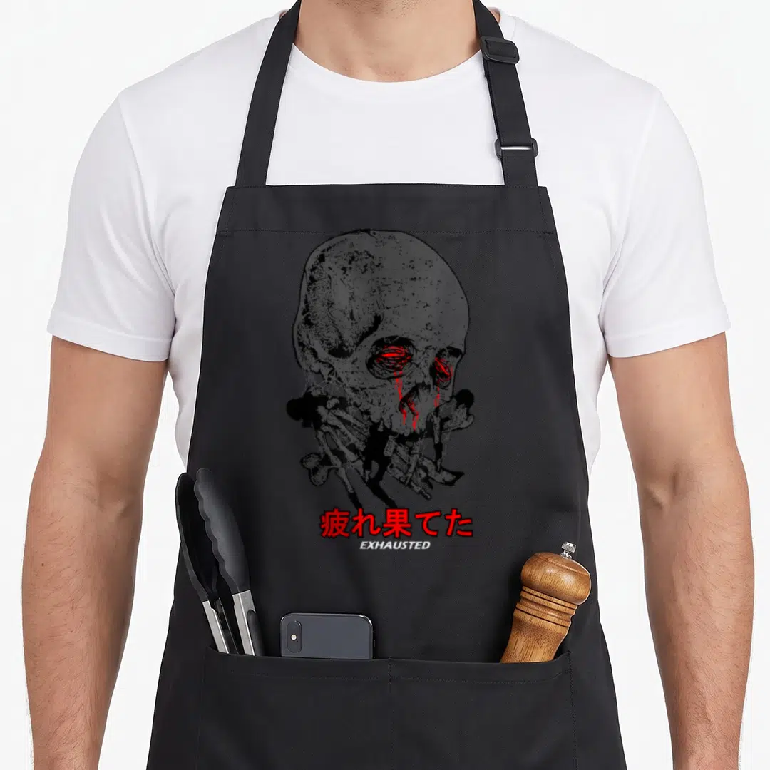 Exhausted japan apron - Grey skull with red eye streaks above red kanji and white EXHAUSTED text — shown on a black cotton canvas apron against a white background