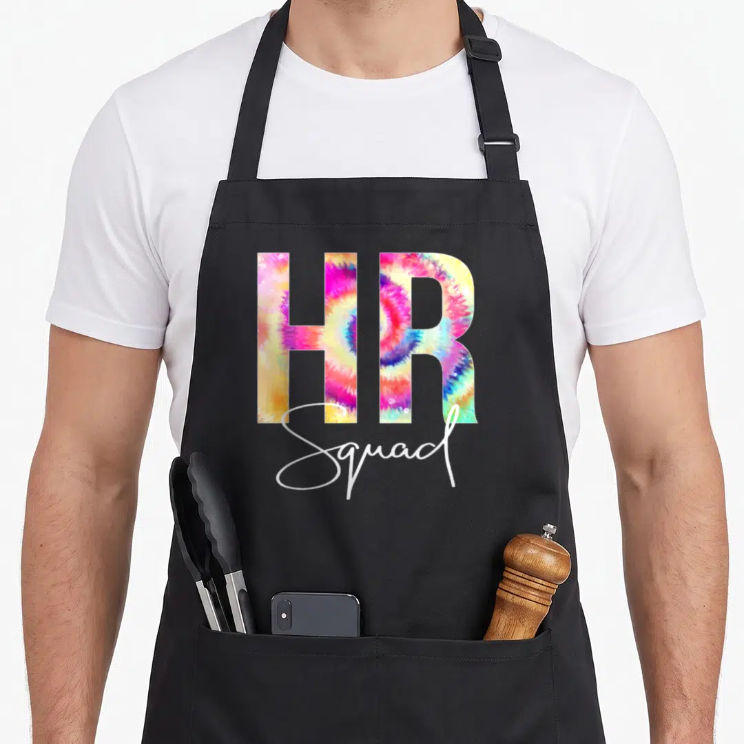 Squad tie-dye apron - HR Squad tie-dye text in pink yellow blue and white on black background — shown on a black cotton canvas apron against a white background