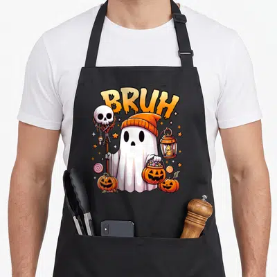 Bruh halloween apron - Cartoon ghost in orange beanie holds skull staff and pumpkin candy bucket under BRUH text — shown on a black cotton canvas apron against a white background