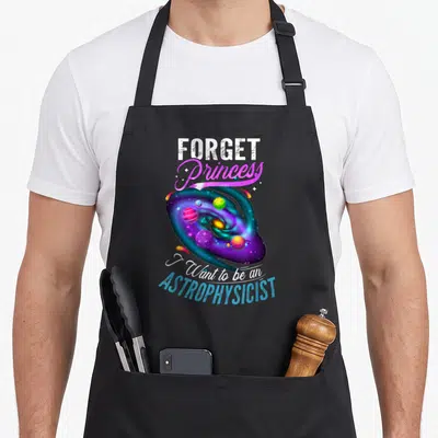 Physic princess apron - Galaxy illustration with planets and text forget princess i want to be an astrophysicist — shown on a black cotton canvas apron against a white background