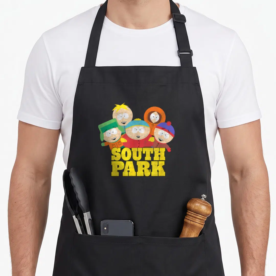 Gang park apron - Four cartoon figures in colorful winter gear above yellow SOUTH PARK text — shown on a black cotton canvas apron against a white background