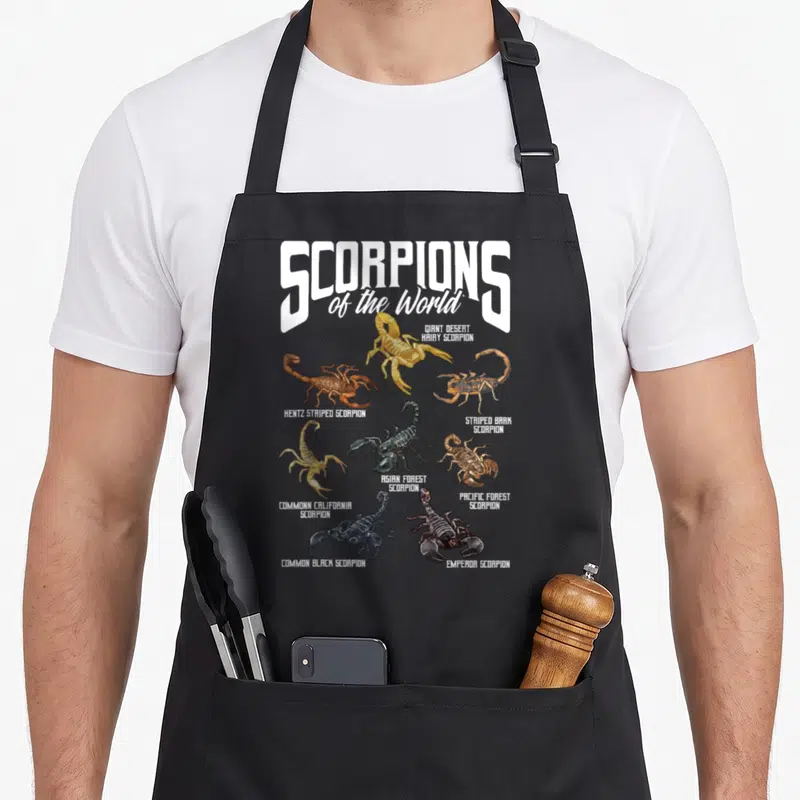 Arachnology animal apron - Seven labeled scorpion illustrations in white, yellow, brown, and black with taxonomy text — shown on a black cotton canvas apron against a white background