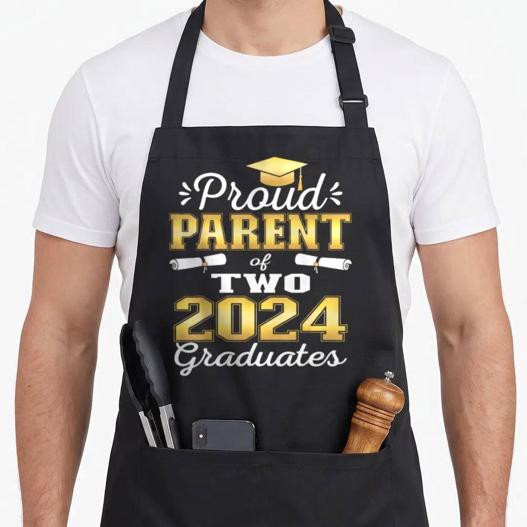 Graduate proud parent apron - Gold graduation cap and two white diplomas flanking text reading Proud Parent of Two 2024 — shown on a black cotton canvas apron against a white background