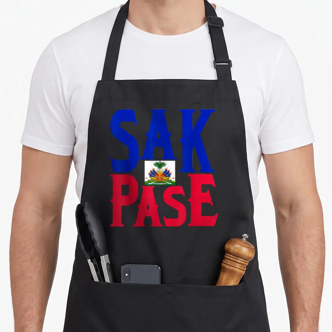 Pase pride apron - SAK PASE text in blue and red with centered coat of arms — shown on a black cotton canvas apron against a white background