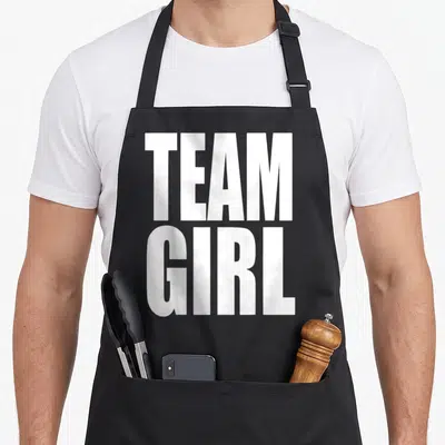 Baby pregnant squad apron - Stacked white TEAM GIRL text in bold sans-serif font — shown on a black cotton canvas apron against a white background