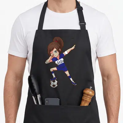 Soccer honduran boy apron - Cartoon girl in blue star-striped kit winking while balancing foot on a soccer ball — shown on a black cotton canvas apron against a white background