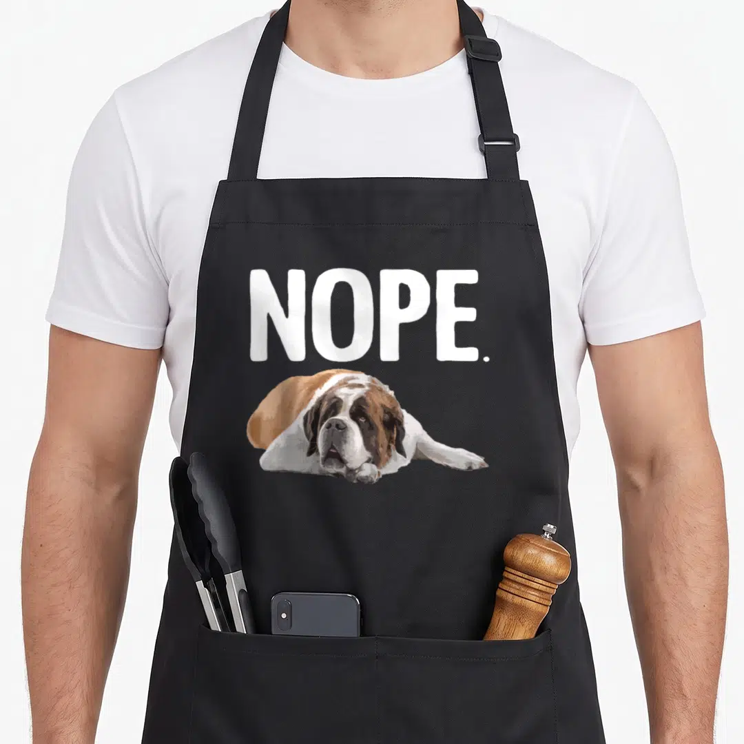 Vintage saint dog apron - NOPE. text above lying Saint Bernard in white brown and black — shown on a black cotton canvas apron against a white background