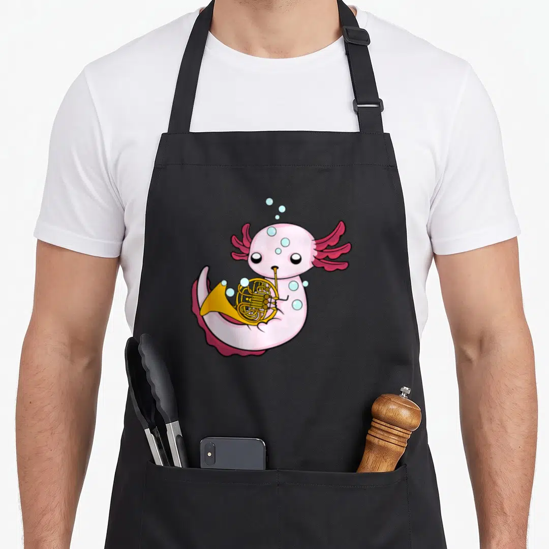 Axolotl french apron - Pink cartoon axolotl holding a gold French horn with scattered blue bubbles — shown on a black cotton canvas apron against a white background