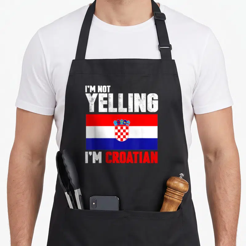 Yelling croatian aprons - I'M NOT YELLING I'M CROATIAN text above red white blue flag — shown on a black cotton canvas apron against a white background