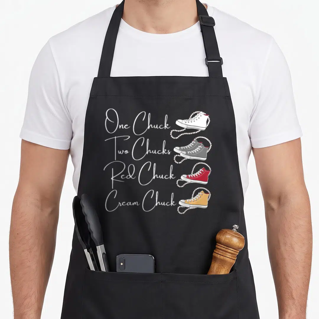 Pearl magic apron - Four sneakers in white grey red and yellow with pearl strings and matching text labels — shown on a black cotton canvas apron against a white background