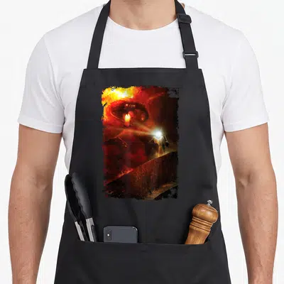 Shall ring apron - Giant red demon head looming over small person holding light on a wall — shown on a black cotton canvas apron against a white background