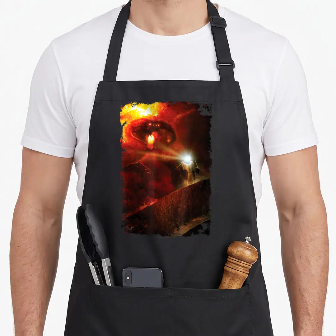 Shall ring apron - Giant red demon head looming over small person holding light on a wall — shown on a black cotton canvas apron against a white background