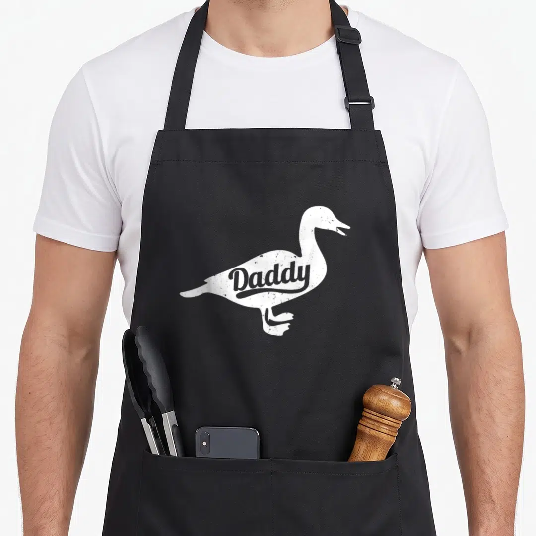 Farm cotton duck apron - White goose silhouette with Daddy text in grey distressed style — shown on a black cotton canvas apron against a white background