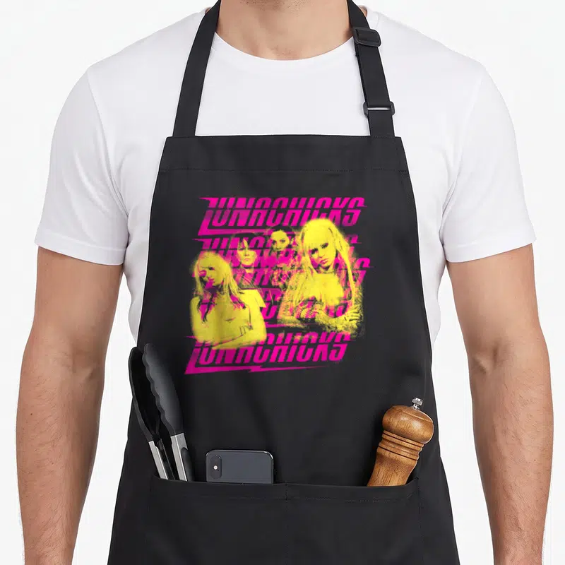 Lunachick novelty apron - Four yellow women clustered behind repeating pink JUNOWAVES text in retro style — shown on a black cotton canvas apron against a white background