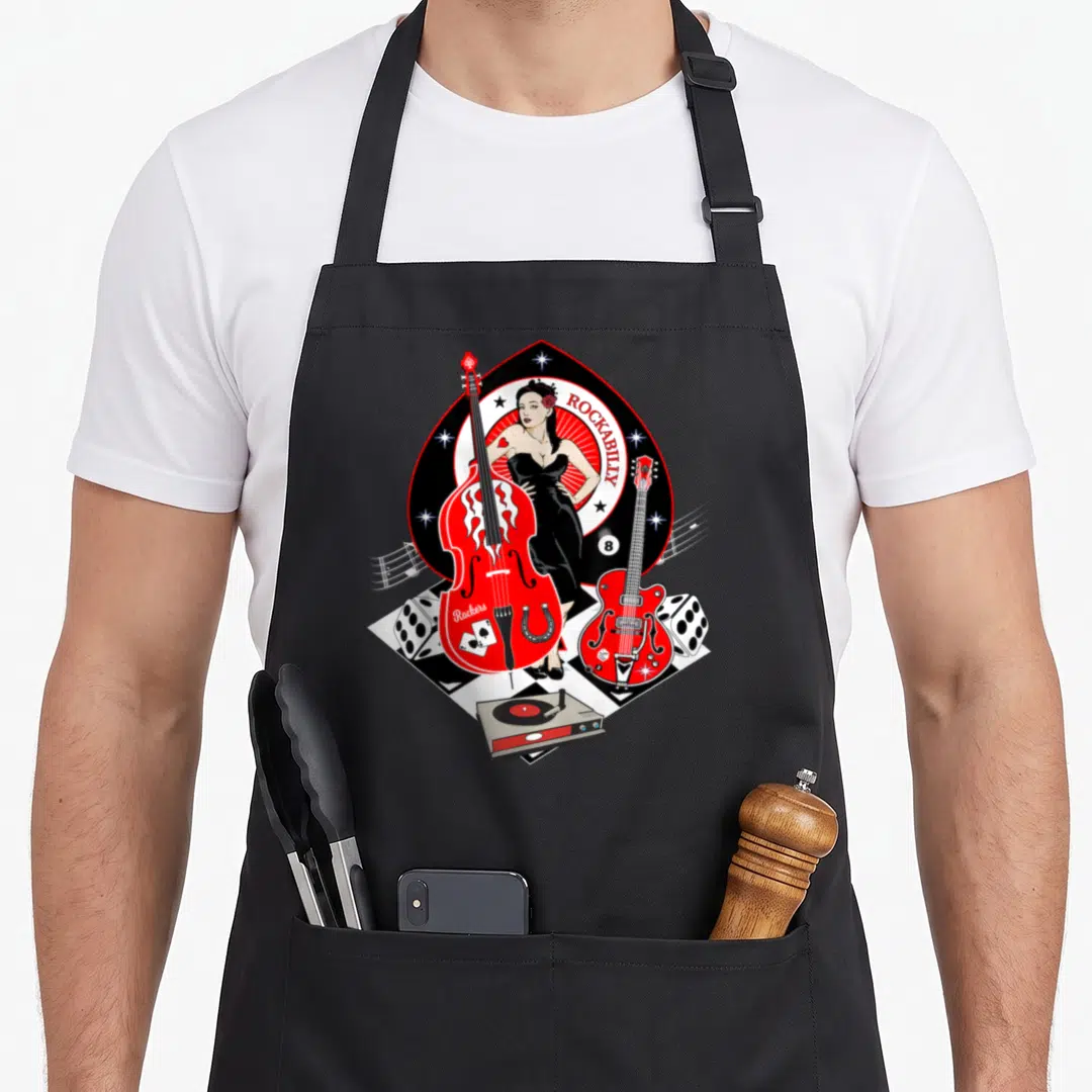 Pinup rockabilly apron - Cartoon woman in black dress with red bass, guitar, dice, and record player on checkered floor — shown on a black cotton canvas apron against a white background