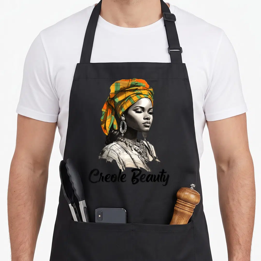 Creole the plaid apron - Woman portrait orange green plaid headwrap Creole Beauty text — shown on a black cotton canvas apron against a white background