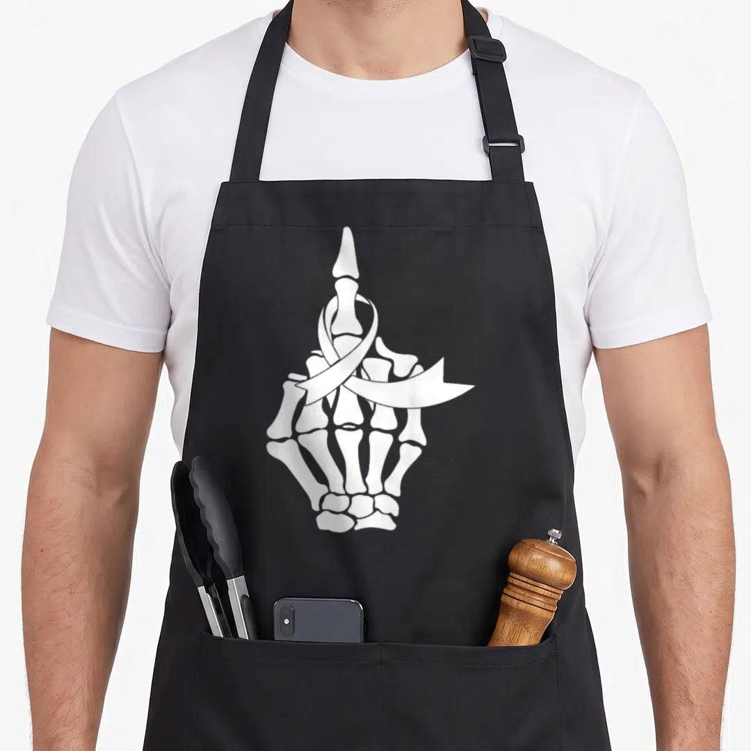 Finger ribbon apron - White line art skeleton hand with awareness ribbon on middle finger — shown on a black cotton canvas apron against a white background