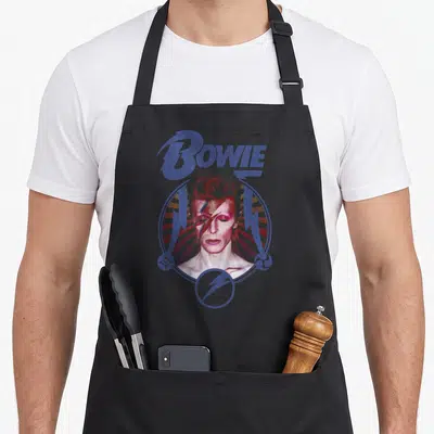 Blue david aprons - Retro David Bowie portrait with blue lightning bolts and arched text on sunburst background — shown on a black cotton canvas apron against a white background